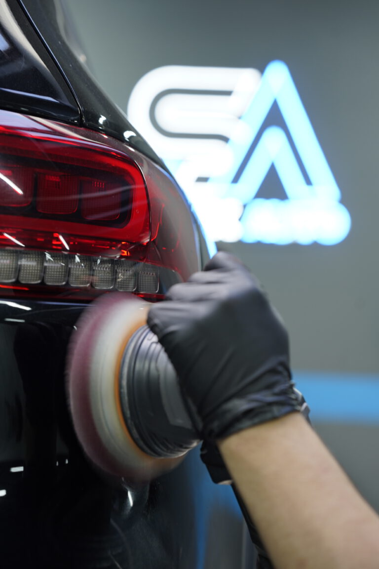 Polisseuse en action sur une carrosserie noire